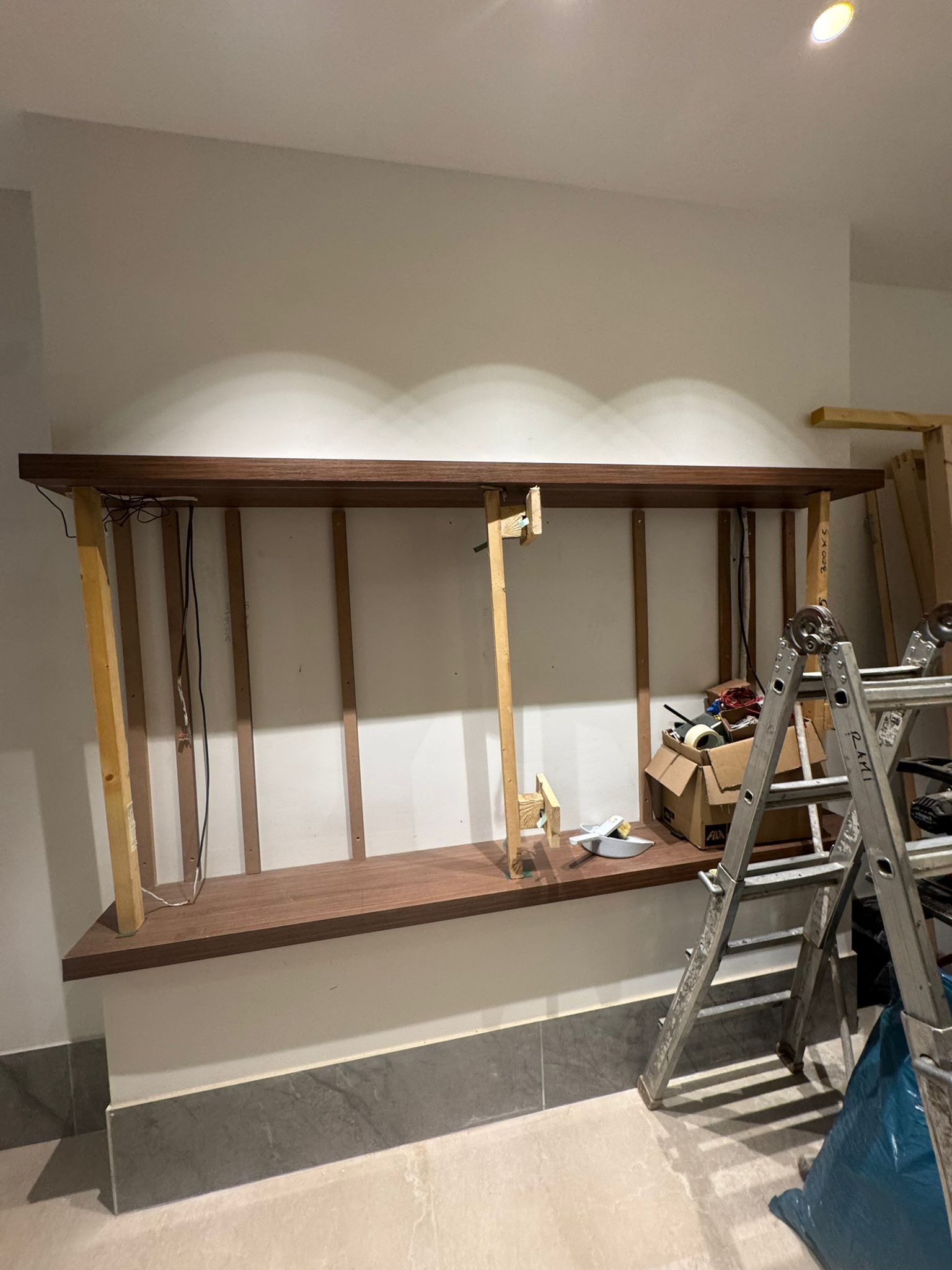 Allestimento di parete attrezzata con struttura in legno e illuminazione
